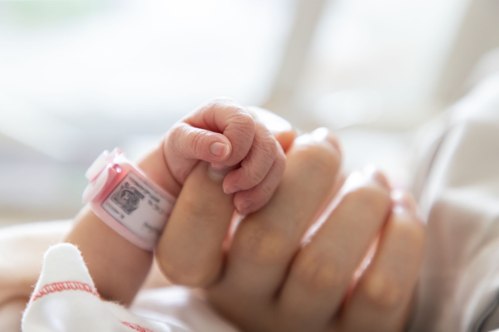 Baby holding a mother’s finger